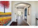 Elegant hallway with hardwood floors, arched doorways, and a vibrant painting at 722 Hutchinson St, Louisville, CO 80027