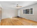 A well-lit room offers a view through the window, hardwood flooring, and a traditional ceiling fan at 805 38Th St, Boulder, CO 80303