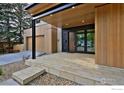 Inviting front porch with stone steps and a modern wood door, complemented by a well-maintained landscape at 864 Iris Ave, Boulder, CO 80304