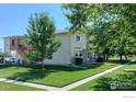 A well maintained house with a green lawn, mature trees, and a charming exterior at 1057 W 112Th Ave # D, Denver, CO 80234