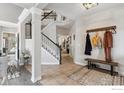 Spacious foyer with tile flooring, staircase, coat rack, and a view into other rooms at 13850 Meadowbrook Dr, Broomfield, CO 80020