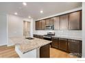 Bright kitchen with granite island, stainless steel appliances, and ample cabinet space at 1419 Great Western Dr, Longmont, CO 80501