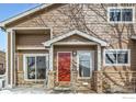 Charming townhome with red front door, brick accents, and well-maintained landscaping at 1601 Great Western Dr # 3, Longmont, CO 80501