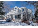 Charming home featuring a covered front porch and second story balconies surrounded by snow covered landscaping at 1601 Redwood Ave, Boulder, CO 80304