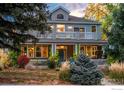 Charming home featuring a covered front porch and second story balconies surrounded by lush landscaping at 1601 Redwood Ave, Boulder, CO 80304