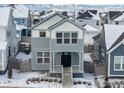 Charming two-story home with a gray facade, inviting front porch, and mountain views at 182 Sassafras St, Erie, CO 80516