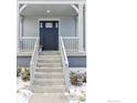 Inviting front porch with gray facade, black door and well-maintained stairs and yard at 182 Sassafras St, Erie, CO 80516