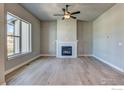 Spacious living room with light hardwood floors, a large window, and a modern fireplace at 202 High Point Dr, Longmont, CO 80504