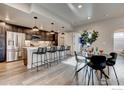 A modern kitchen with stainless steel appliances, dark cabinets, a white countertop island, and barstool seating at 265 High Point Dr # 101, Longmont, CO 80504