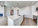 Open kitchen with island, stainless sink, pendant lighting, and easy flow to great room and fireplace at 265 High Point Dr # 201, Longmont, CO 80504