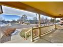 A covered porch with white railings offers serene views of the neighborhood at 288 Dover Ct, Broomfield, CO 80020