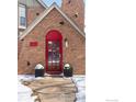 Close-up of the elegant red front door with glass panels, framed by potted plants and brick facade at 3584 Kirkwood Pl, Boulder, CO 80304