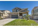 Charming two-story home featuring stone accents, a covered front porch, and a well-maintained front lawn at 458 Highlands Cir, Erie, CO 80516