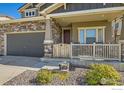 Close-up of front door and porch with a stone facade, and an inviting entrance with a decorative wreath at 458 Highlands Cir, Erie, CO 80516