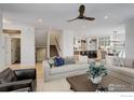 Bright living room with neutral color palette, hardwood floors, and view to kitchen and stairs at 711 William Way, Berthoud, CO 80513