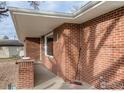 Side view of a well-maintained brick home with an inviting covered porch at 830 10Th St, Berthoud, CO 80513