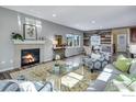 Bright living room featuring fireplace, modern decor, stylish area rug, and wood-accent wall at 956 Equinox Dr, Erie, CO 80516