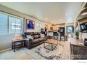 Inviting living room with comfortable seating, stylish rug, and ample natural light from a large window at 1117 Hummingbird Cir, Longmont, CO 80501