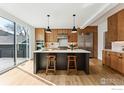Modern kitchen features an island with bar seating, stainless steel appliances, wood cabinets, and hardwood flooring at 2122 Goss Cir, Boulder, CO 80302