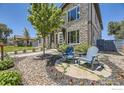 Well-maintained front yard featuring a stone patio area with chairs, lush landscaping, and a beautiful stone-accented home exterior at 2235 Cherokee St, Denver, CO 80223