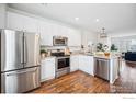 Modern kitchen with stainless steel appliances, white cabinetry, and wood flooring at 4141 W 118Th Pl, Westminster, CO 80031