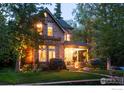 Stone home with a manicured lawn, lush landscaping, and a welcoming front porch at 643 Mapleton Ave, Boulder, CO 80304