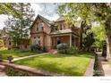 Charming stone home with a well-manicured lawn, lush landscaping, and classic architectural details at 643 Mapleton Ave, Boulder, CO 80304