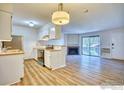 Bright, open living space features wood flooring, a fireplace, and an attached kitchen at 695 Manhattan Dr # 216, Boulder, CO 80303