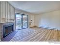 Spacious living room featuring modern flooring, fireplace, and glass sliding door access to an outdoor patio at 695 Manhattan Dr # 216, Boulder, CO 80303