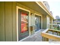 Condo patio with view through the front door, sliding window, and a rustic wooden railing at 695 Manhattan Dr # 216, Boulder, CO 80303