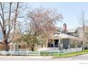 Beautiful home with a white picket fence and a mature tree in full bloom at 730 Evergreen Ave, Boulder, CO 80304