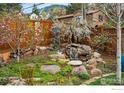 Landscaped backyard featuring a waterfall and mature trees and shrubbery at 851 14Th St, Boulder, CO 80302
