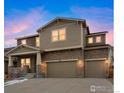 Attractive two-story home featuring a stone facade, a covered porch and a three-car garage at 887 Sundance Ln, Erie, CO 80516