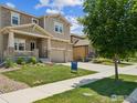 Charming home with stone accents, a covered porch and manicured lawn and landscaping at 887 Sundance Ln, Erie, CO 80516
