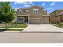 Beautiful two-story home featuring a stone facade, inviting porch, manicured lawn and a three-car attached garage at 887 Sundance Ln, Erie, CO 80516