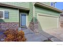 Inviting home exterior featuring a blue front door, stone accents, and a two-car garage at 10117 Wyandott N Cir, Thornton, CO 80260