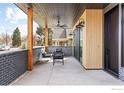 Inviting covered porch with stylish seating, wood columns, and brick surround at 1223 Main St, Louisville, CO 80027