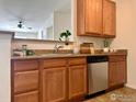 Well-lit kitchen features stainless steel dishwasher and granite countertops at 1465 Blue Sky Cir # 303, Erie, CO 80516