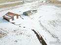 Stunning aerial view showcasing the house and garage on a vast, snow-covered lot at 17910 County Road 38, Platteville, CO 80651