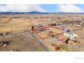 Expansive aerial view of property with outbuildings and fenced perimeter showcasing mountain views at 200 Bothun Rd, Berthoud, CO 80513