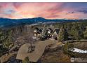 Stunning aerial view of log home surrounded by lush trees and breathtaking mountain views at 2101 Bison Dr, Boulder, CO 80302