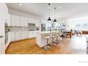 Spacious kitchen island with seating, white cabinets, and stainless steel appliances at 22674 E Henderson Dr, Aurora, CO 80016