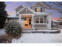 Charming two-story home with gray siding, a covered front porch, and a well-manicured front yard dusted with snow at 2429 Tyrrhenian Dr, Longmont, CO 80504