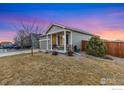 A single-story home with neutral siding, a covered porch, and a green lawn at 2912 Urban Pl, Berthoud, CO 80513