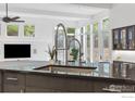 Modern kitchen island with a stainless steel faucet and black countertop, surrounded by natural light from large windows at 2925 4Th St, Boulder, CO 80304