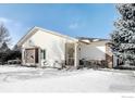 Well-maintained single-story home showcasing clean lines, a cozy porch, and wintery yard with mature trees at 3025 Depo Dr, Longmont, CO 80503