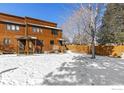 Cozy townhouse showcasing a snow-covered backyard with a wooden fence and bare trees on a sunny day at 3323 Hickok Pl, Boulder, CO 80301