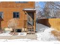 Inviting townhouse entrance with wooden steps and a charming front door, nestled in a snowy setting at 3323 Hickok Pl, Boulder, CO 80301