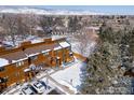 Aerial view of townhouse with snowy backyard and a parking spot, surrounded by lush trees and mountains at 3323 Hickok Pl, Boulder, CO 80301