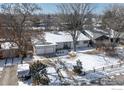 Aerial view of a charming home with a two-car garage and a snow-covered yard in a quiet neighborhood at 390 W 3Rd Ave Dr, Broomfield, CO 80020